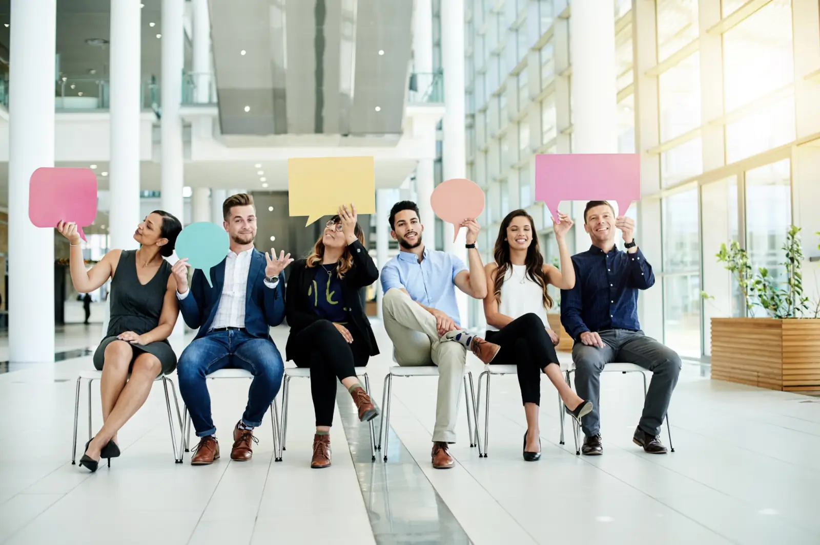 people sitting in a row holding blank signs